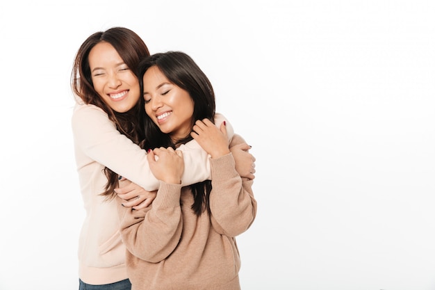 Two asian cute ladies sisters standing isolated