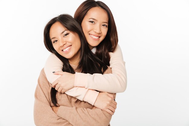 Two asian pretty cheerful ladies sisters