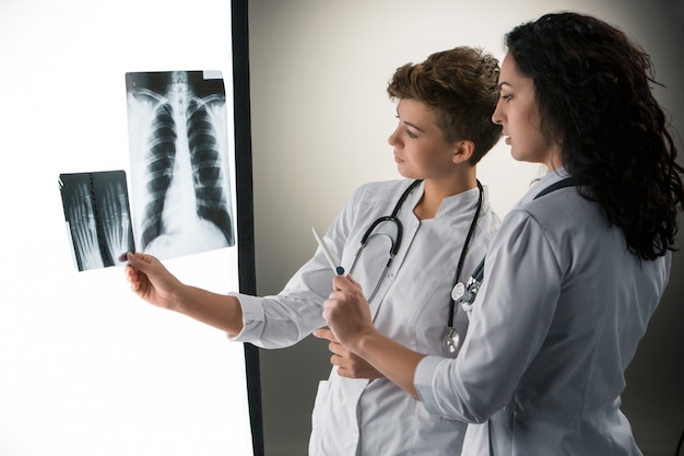 Two attractive young doctors looking at x-ray results