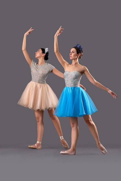 Two ballerinas in dresses and ballet shoes and posing