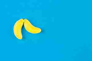 Foto gratuita due caramelle alla banana su sfondo blu