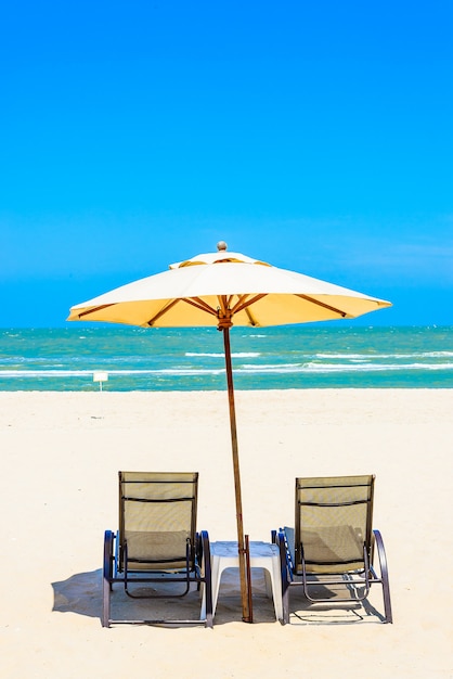 Free photo two beach chairs on white sand