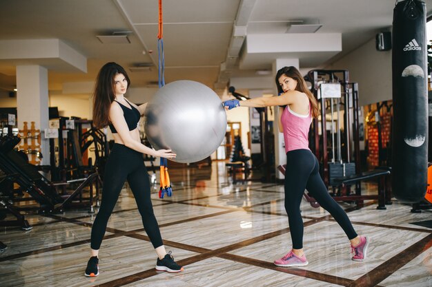 두 아름다운 운동 여자는 체육관에 종사하고있다