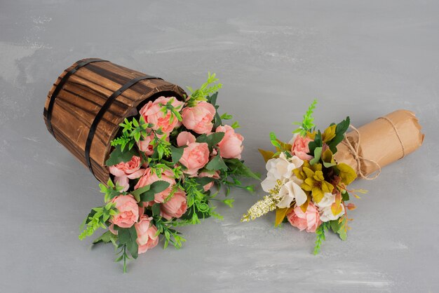 Two beautiful bouquets of flowers on grey surface.