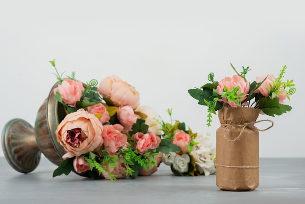 Two beautiful bouquets of flowers on grey surface.