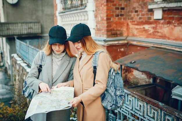 Free photo two beautiful girls with a map