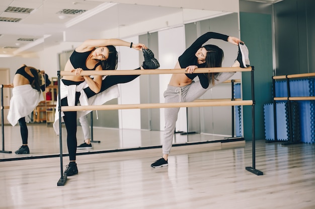 two beautiful slender girls doing dancing and gymnastics in the dance hall