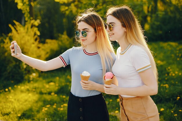 two beautiful young beautiful girls with shiny blond hair and a skirt and walk 