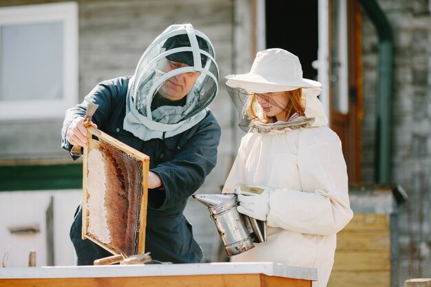 養蜂場で働く2人の養蜂家。つなぎ服での作業。
