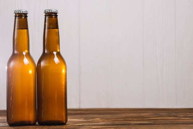 Two beer bottles on wooden surface