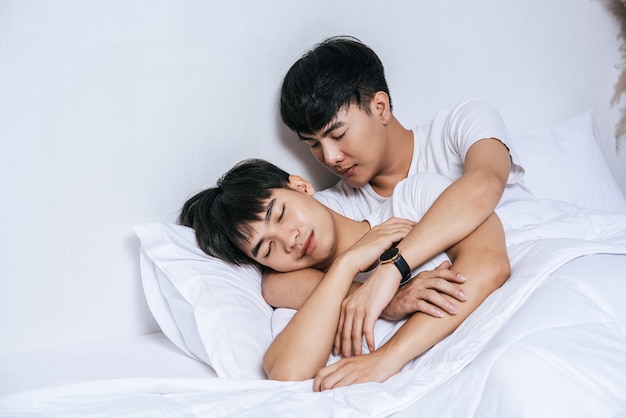 Free photo two beloved young men slept in bed together.