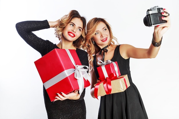 Two best friends making self portrait, spending great time together on new year party. White background.