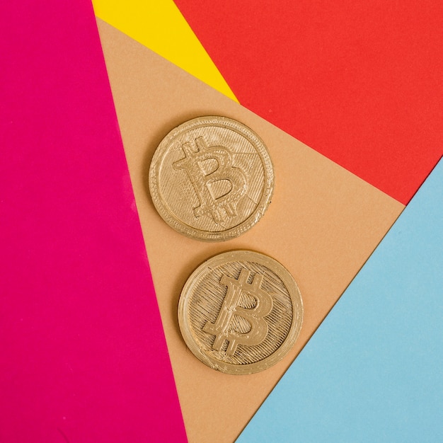 Two bitcoins on many colorful background
