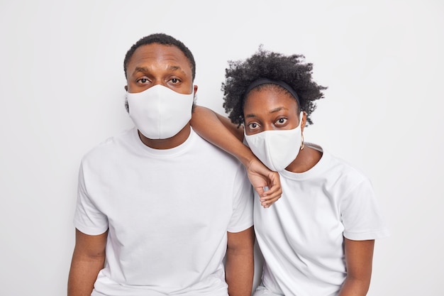 Two black Afro American woman and man wear protective face masks during covid 19 pandemic 