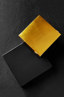 질감 있는 표면에 두 개의 검은색과 황금색 판지 상자