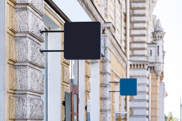 Two Blank mock up design of cafe signboard outdoors on yellow wall