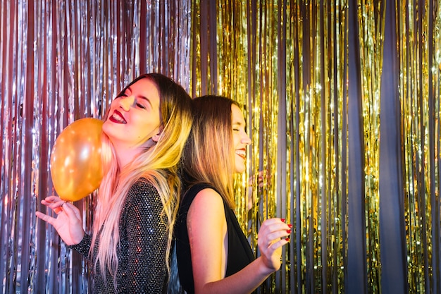 Two blonde girls dancing at new year party