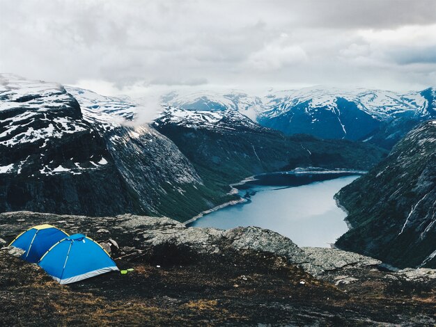 Two blue tents stand before a gorgeous mountain view