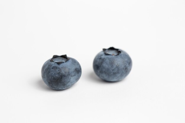 Two blueberries isolated on a white surface