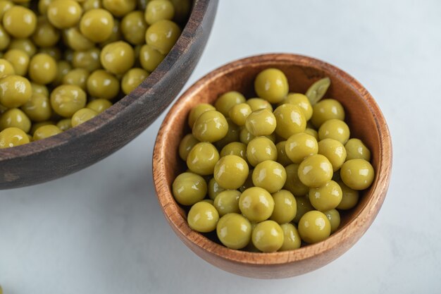 Two bowl full with marinated green peas  .