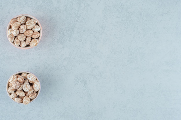 Free photo two bowls full of sweet delicious gingerbread on white surface