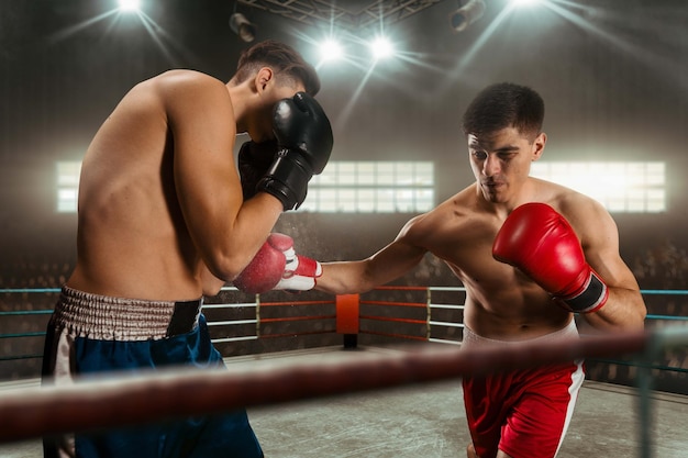 Foto gratuita due pugili stanno combattendo sul ring di pugilato professionistico