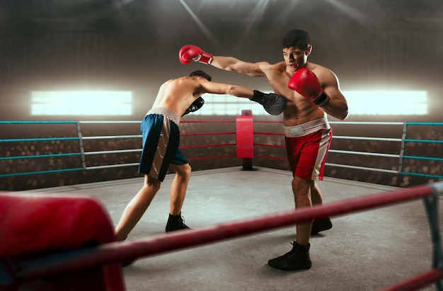 Two boxers are fighting on professional boxing ring