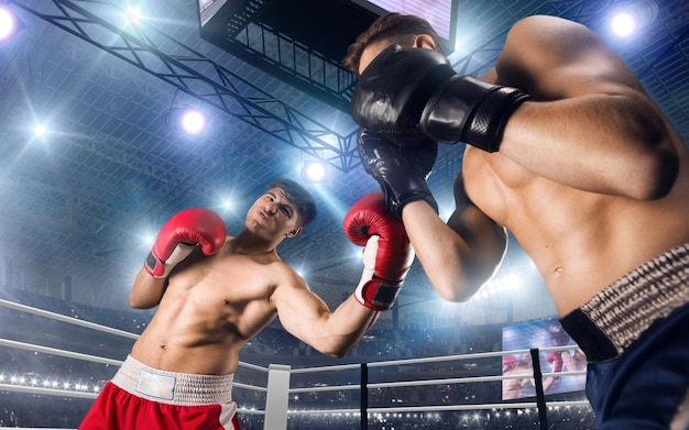 Free photo two boxers fighting on professional boxing ring
