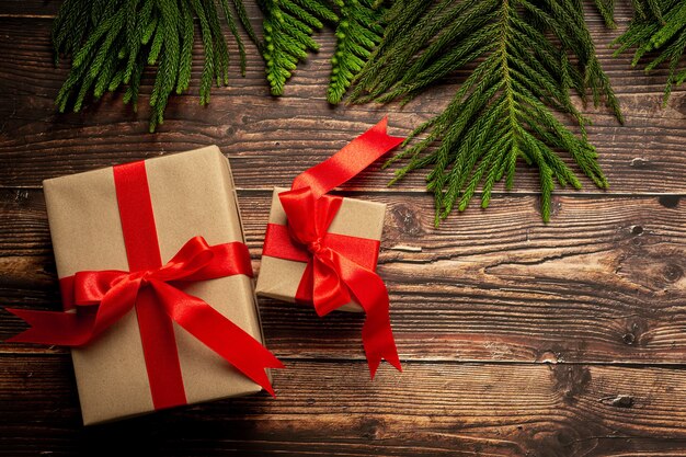 Two boxes of present with red ribbon bow on wooden background