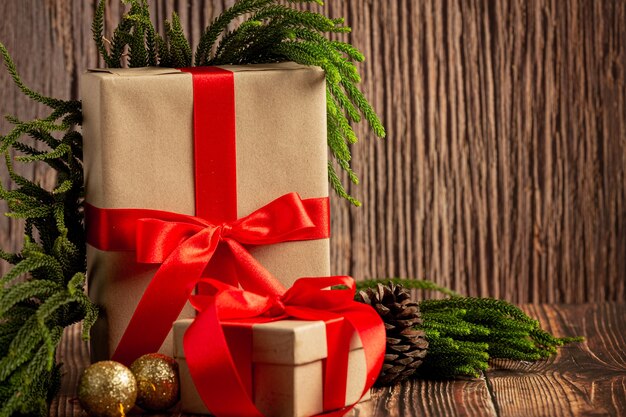 木製の背景に赤いリボンの弓とプレゼントの2箱