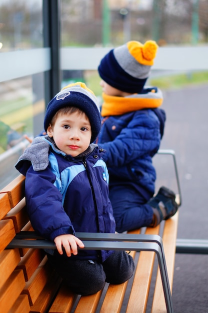 Two boys on a bench waiting