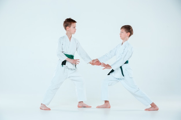 武道学校で合気道の訓練で戦っている2人の少年。健康的なライフスタイルとスポーツコンセプト