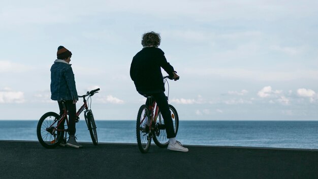 自転車とコピースペースを持って街の屋外にいる2人の男の子