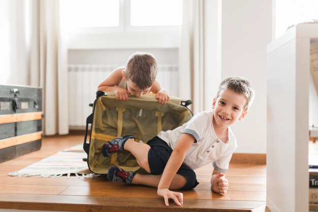 Two boys playing with luggage