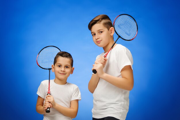 The two boys with badminton rackets outdoors