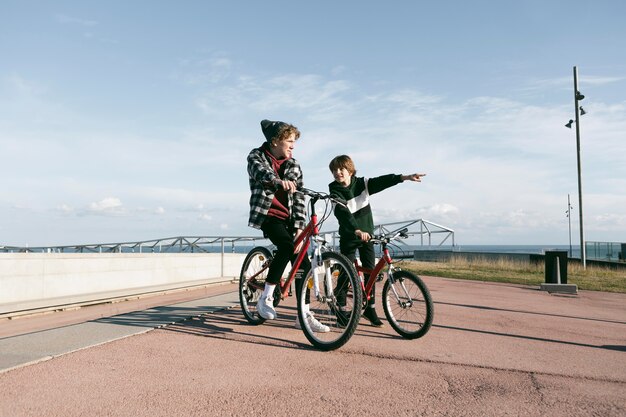 屋外で自転車を持っている2人の男の子