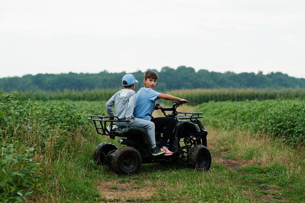 사륜차 ATV 쿼드 바이크를 운전하는 두 형제 행복한 아이들의 순간