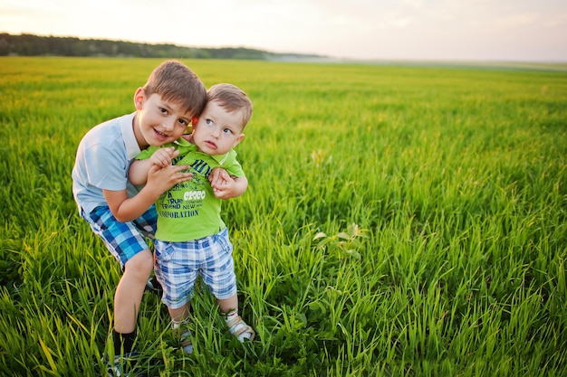 Free photo two brothers in green grass field