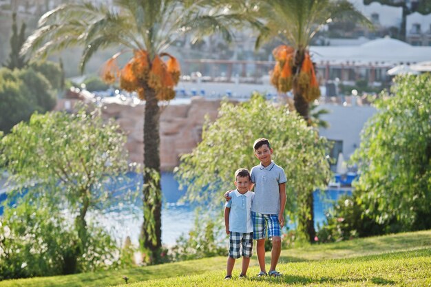 Two brothers on Turkey resort against palms