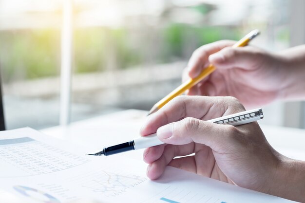 Two business partners analysing a financial report discussing the statistics and performance of their company.