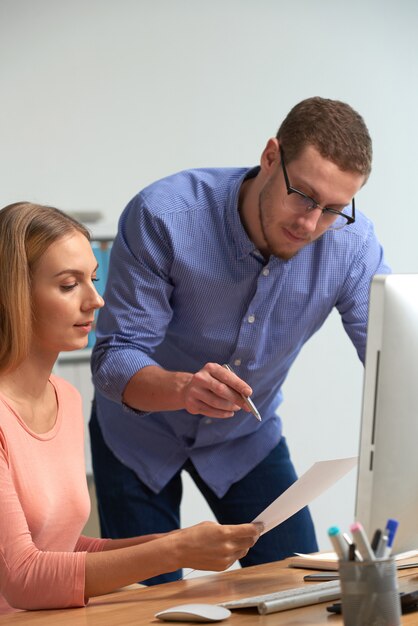 Two business partners discussing business statistics using the paperwork