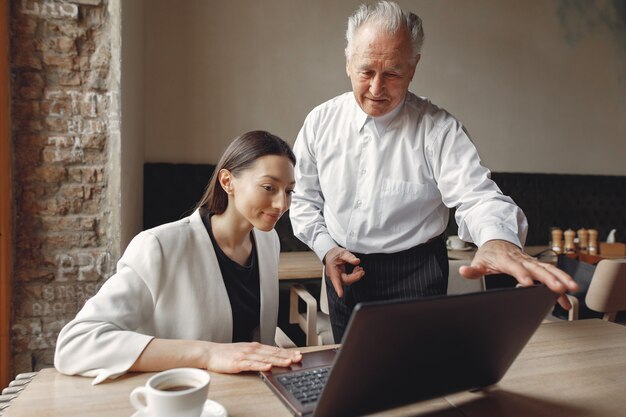 Two business partners working with a laptop in a cafe