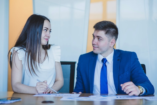 Free photo two business people at a desk looking at each other