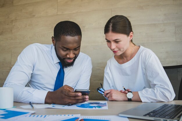 Two business people looking at smartphone