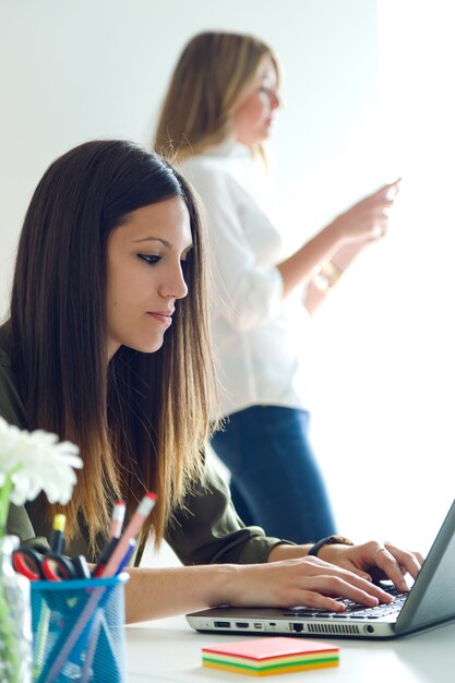 Two business woman working in her office.