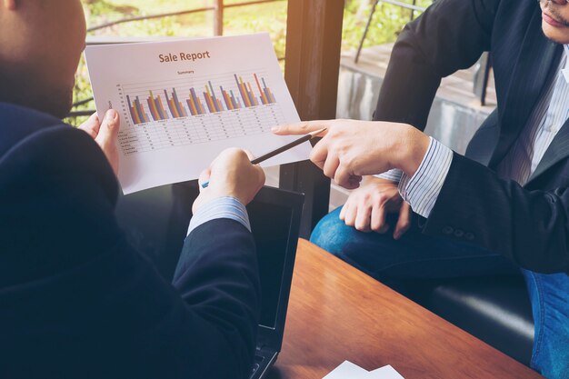 Two businessman discussing their chart in coffee shop