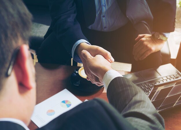 Two businessman shake hand in coffee shop