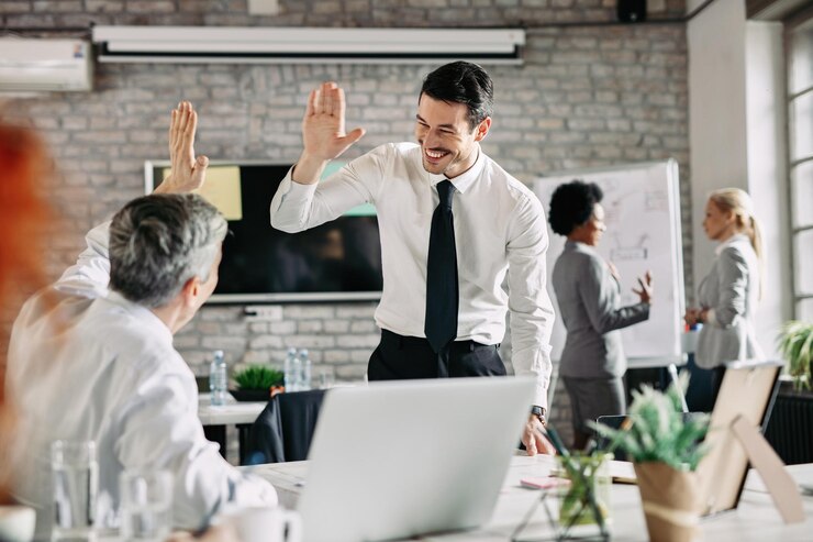Free Photo two businessmen congratulating to each other on successful job and giving highfive focus is on young businessman