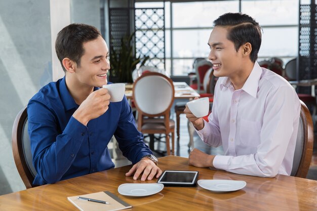 Two Businessmen Drinking Coffee in Restaurant