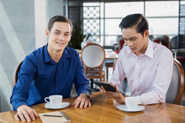 Two Businessmen Having Coffee Break in Restaurant